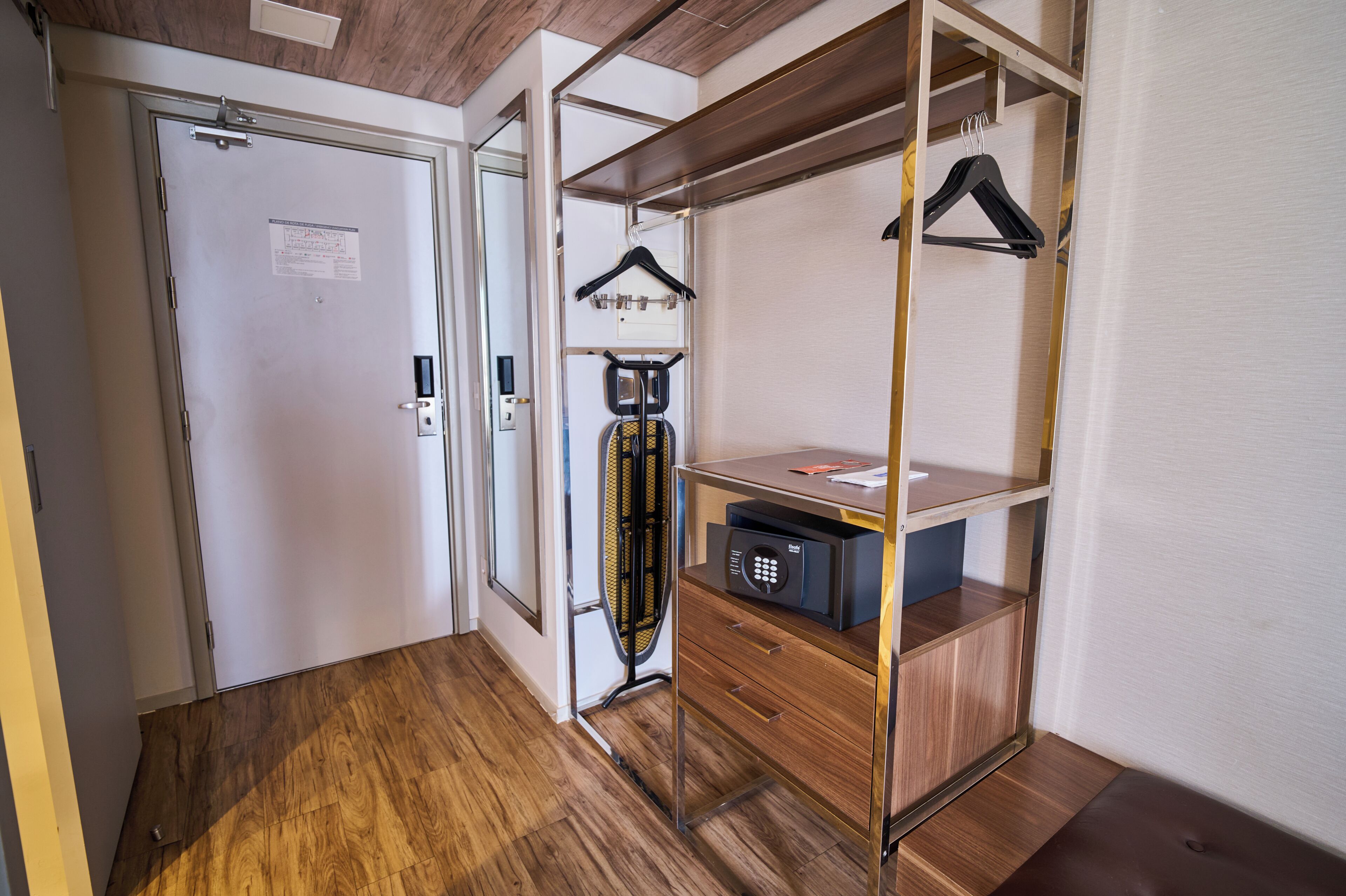 Un armario amplio con un zapatero, una caja fuerte pequeña y un mueble de madera.