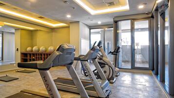 Una palestra con tapis roulant, palle da ginnastica e uno specchio a parete.