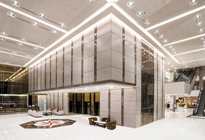 A spacious lobby with a modern design, featuring a central seating area, a large decorative floor pattern, and a prominent reception desk. - Best Western Plus Wanda Grand Hotel (Pak Kret)