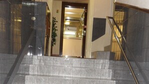 A marble staircase with a handrail leading to a doorway. - Hotel Porto Rico (Porto)