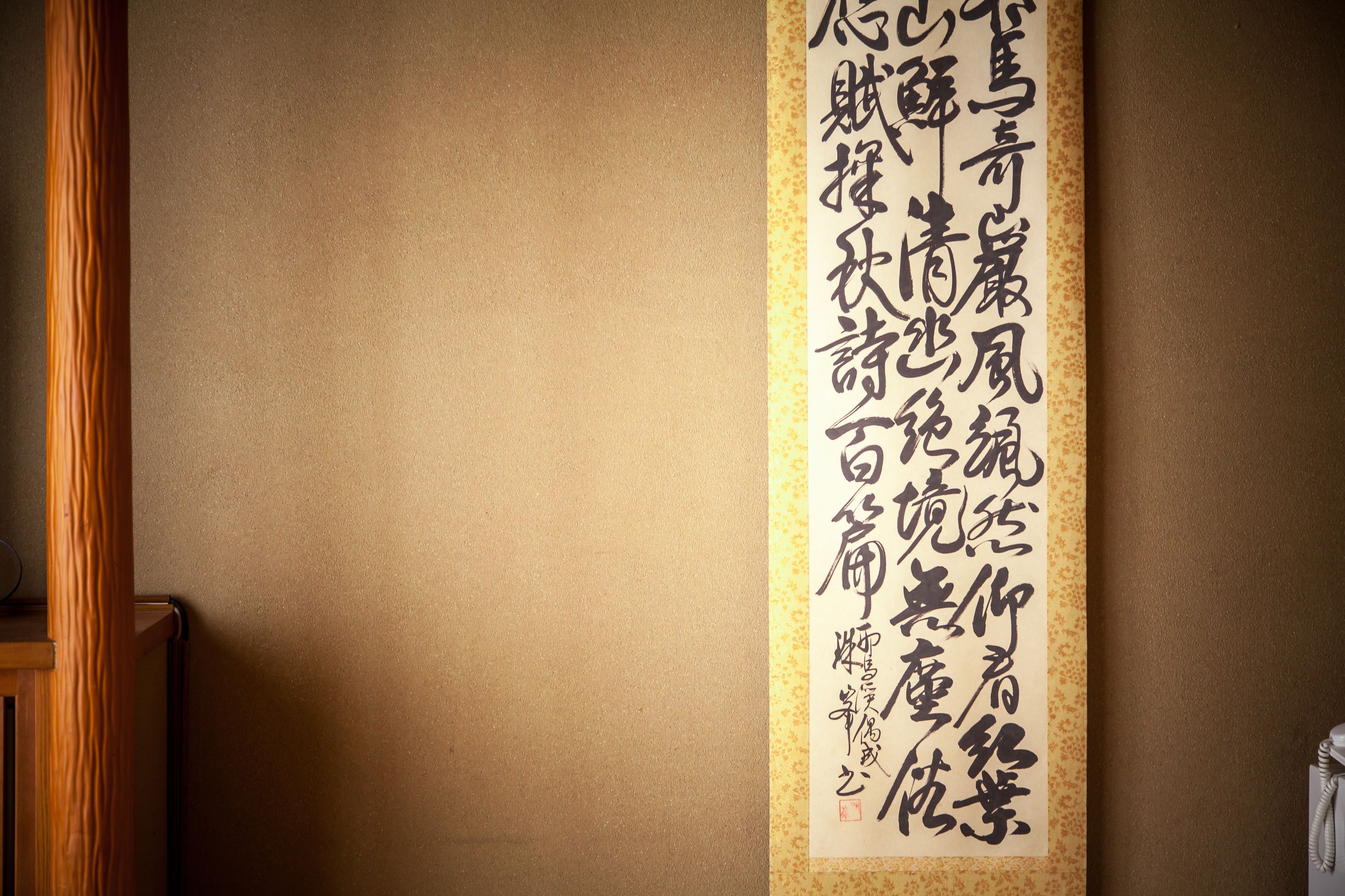 Un rouleau de calligraphie japonaise traditionnelle accroché au mur.