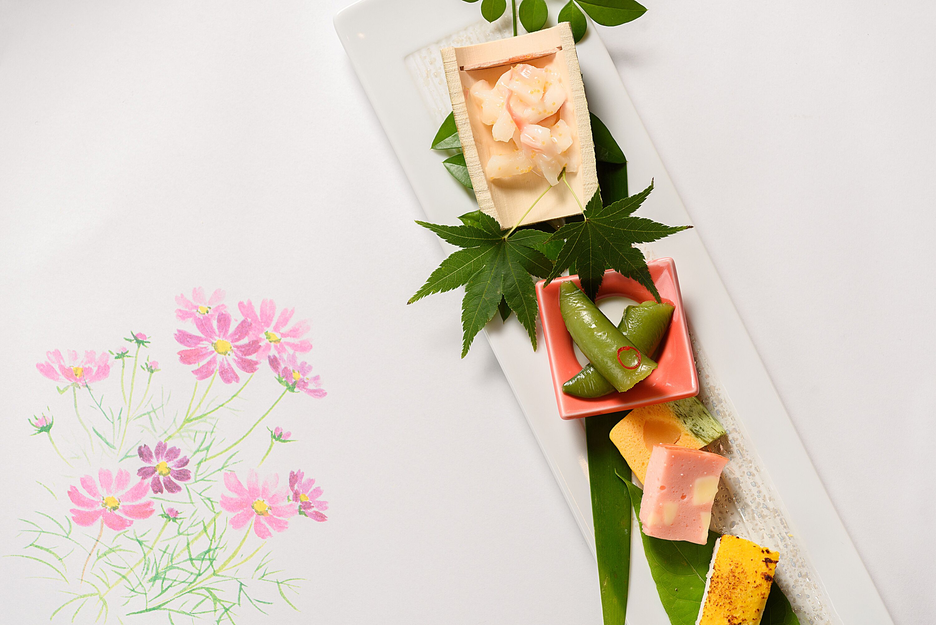 Una bandeja con diferentes alimentos y una pintura floral al estilo acuarela.