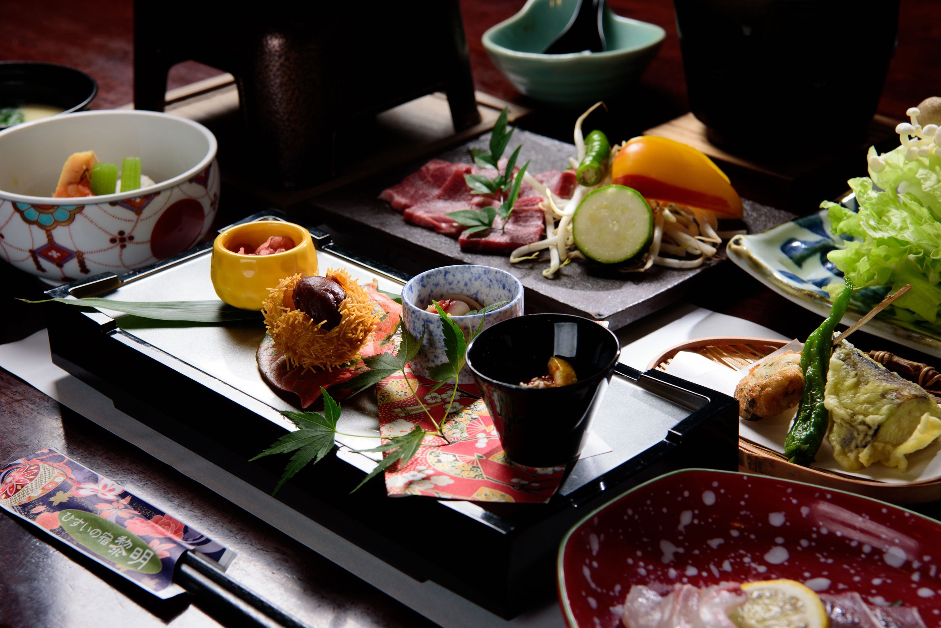 A traditional Japanese meal with various dishes and utensils on a tray.