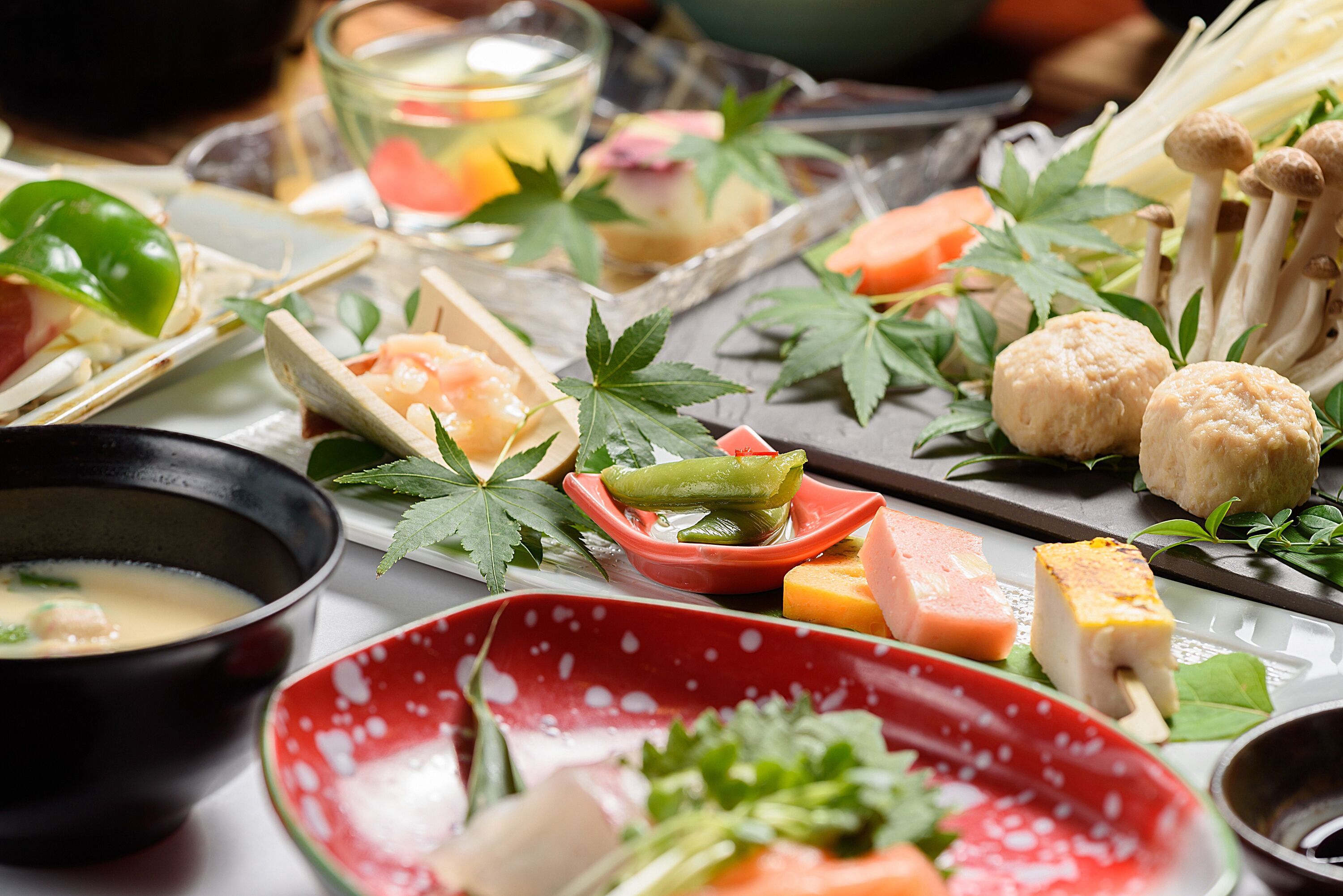 A variety of food items including sushi, sashimi, and vegetables on a table.