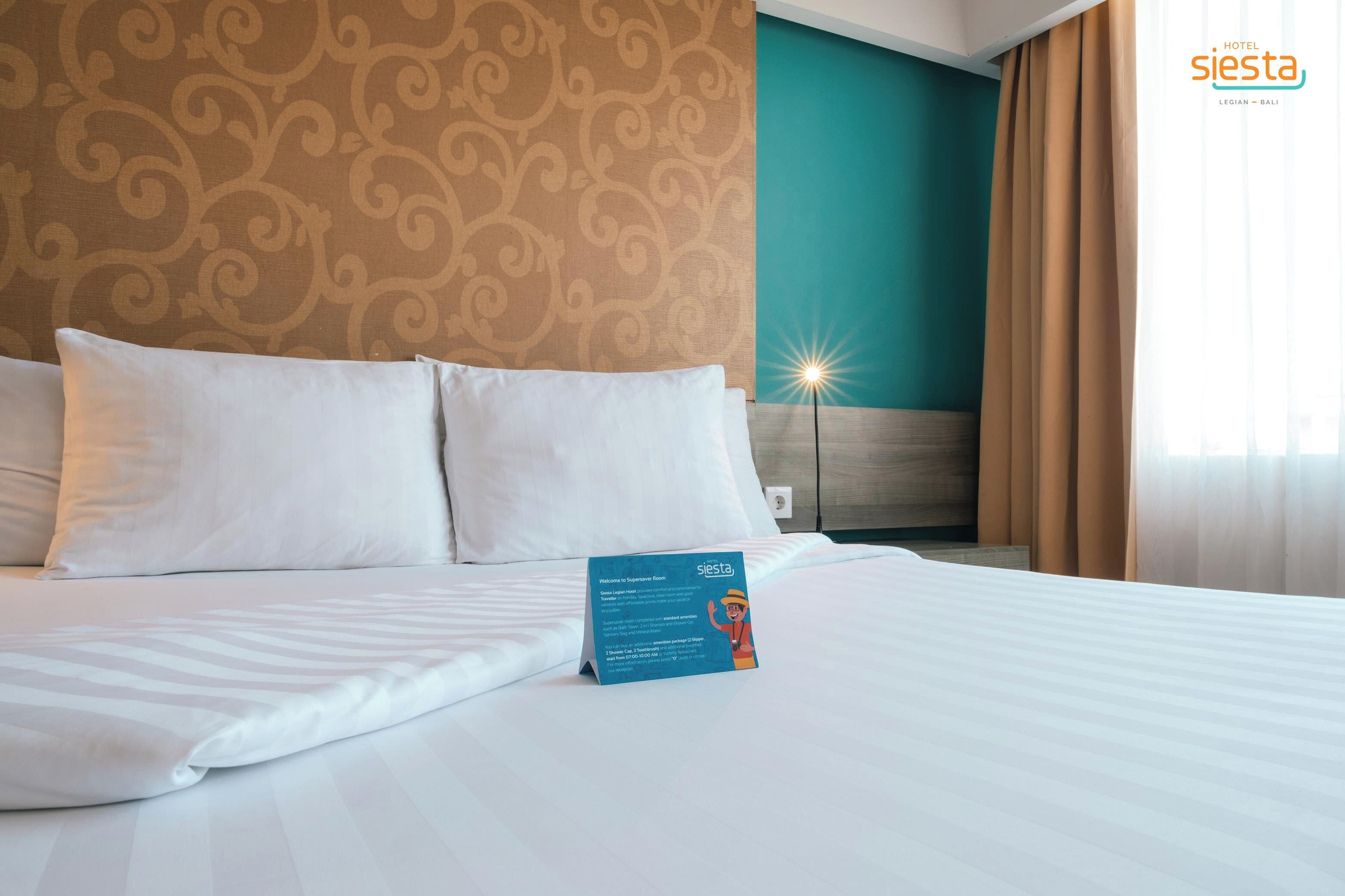 Una habitación de hotel con una cama, un cartel y una pared con un diseño.