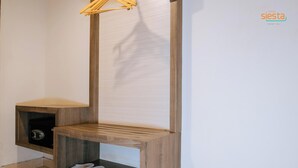 A corner of a room with a wooden bench, a shoe rack, and a small shelf. - Siesta Legian Hotel (Legian)