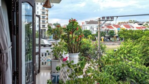 A balcony with potted plants and a view of a residential area. - The House 36 (Da Nang)
