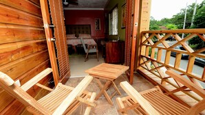 Een houten kamer met een bed, een bureau en twee houten stoelen.