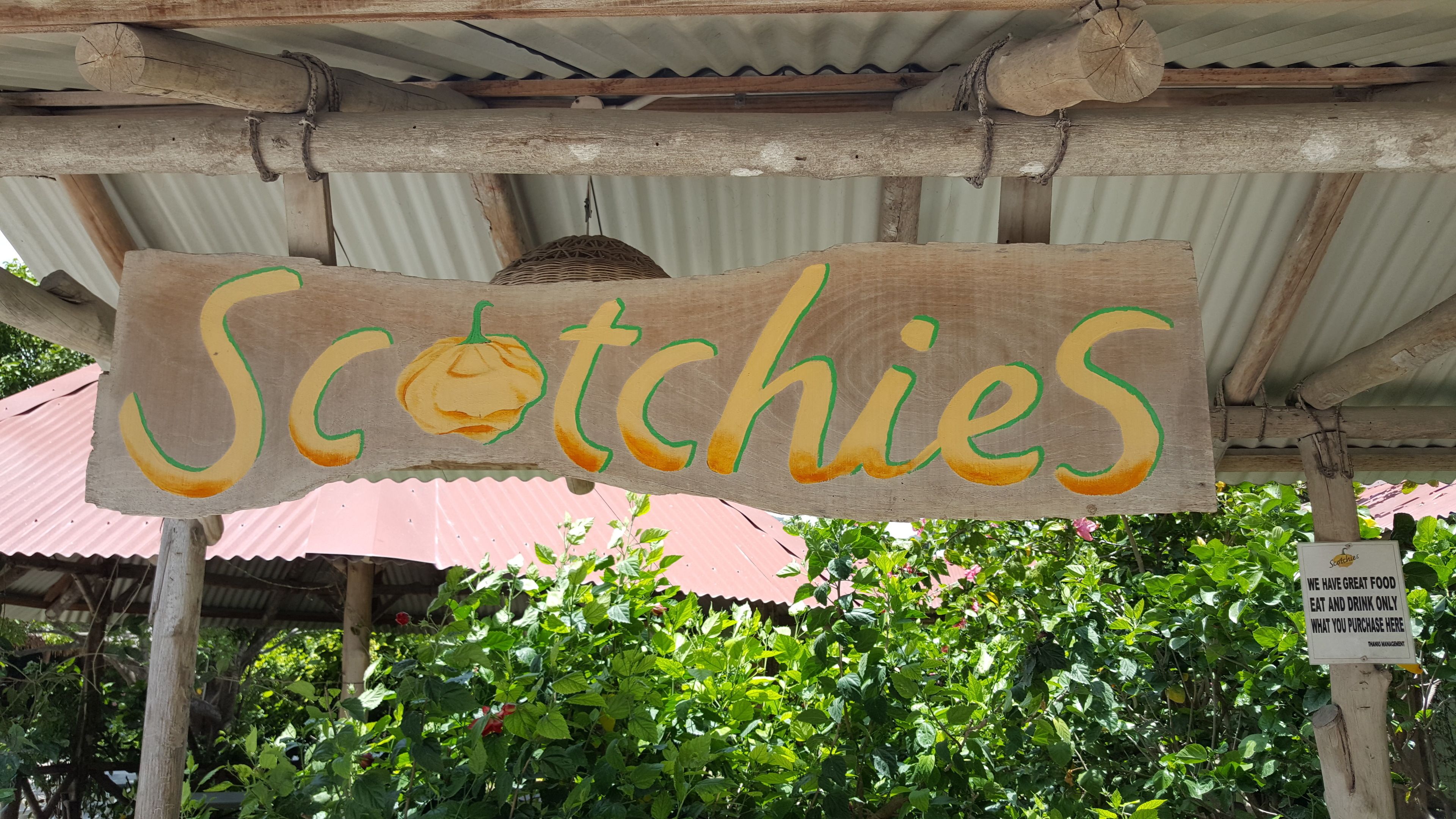 Ein hölzernes Schild mit der Aufschrift "Scotchies" und einer Zeichnung einer Kartoffel.