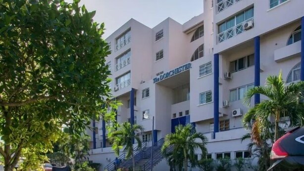 Un hôtel à plusieurs étages au design moderne, doté de balcons et d’un escalier central.