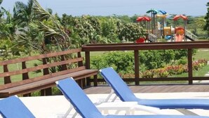A pool area with blue lounge chairs and a wooden deck. - Ocho Rios Ocean View Villa at The Palms (St. Ann's Bay)