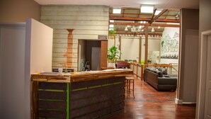 Une cuisine moderne avec un îlot central en bois, un coin repas avec un canapé et une vue sur l’extérieur.