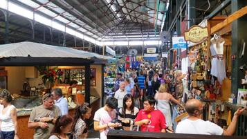 A bustling indoor market with various stalls and a high ceiling.
