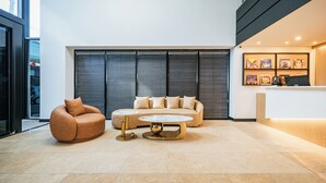 Un hall d’entrée moderne avec un canapé, une table basse ronde et un comptoir d’accueil.
