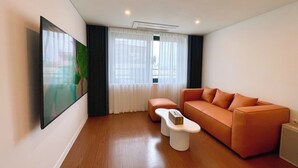 Un salon moderne avec un canapé, une table basse et un tableau accroché au mur.