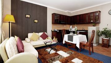 A living room with a sofa, a coffee table, and a dining area with a table and chairs.