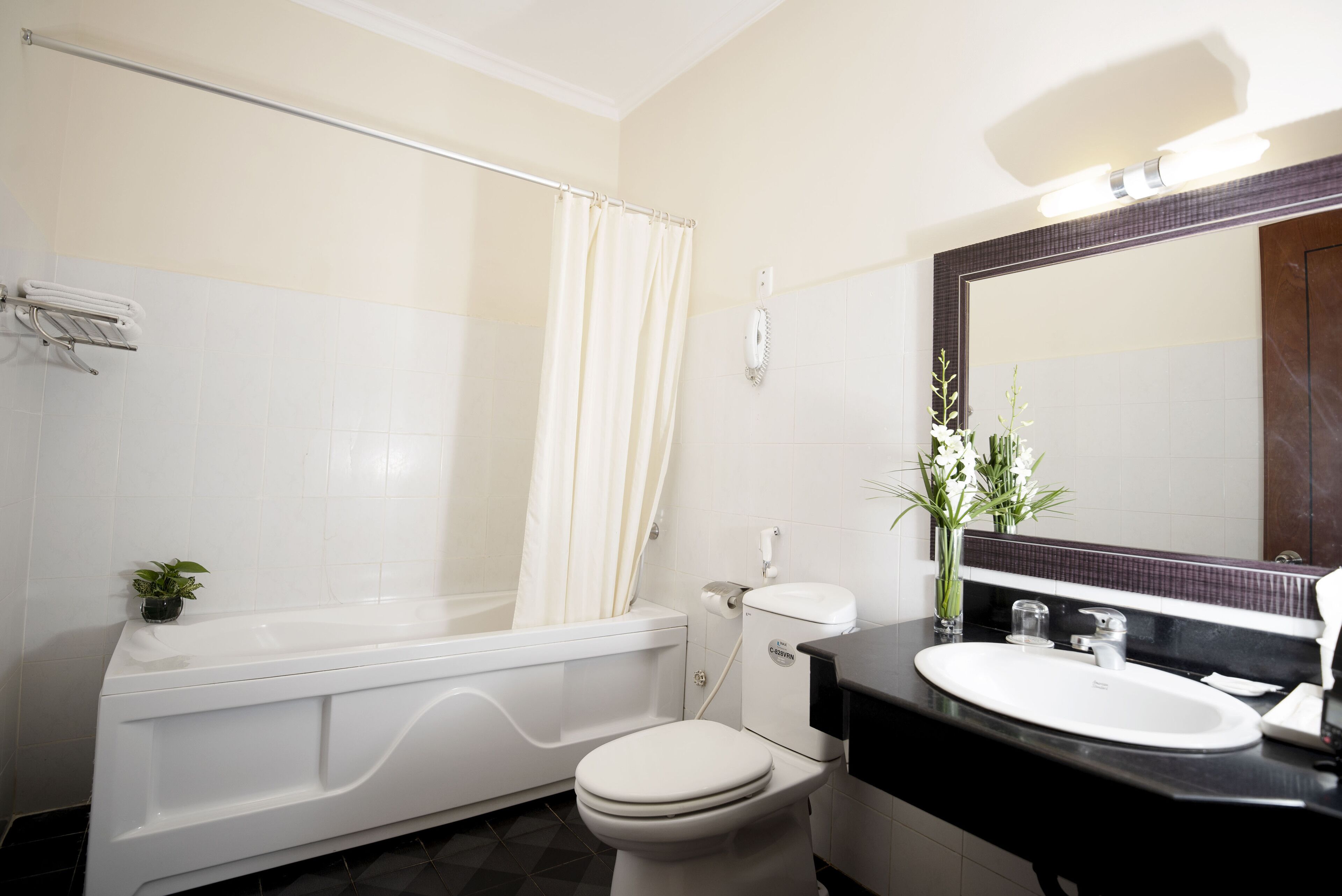 A bathroom with a bathtub, toilet, sink, and a mirror.