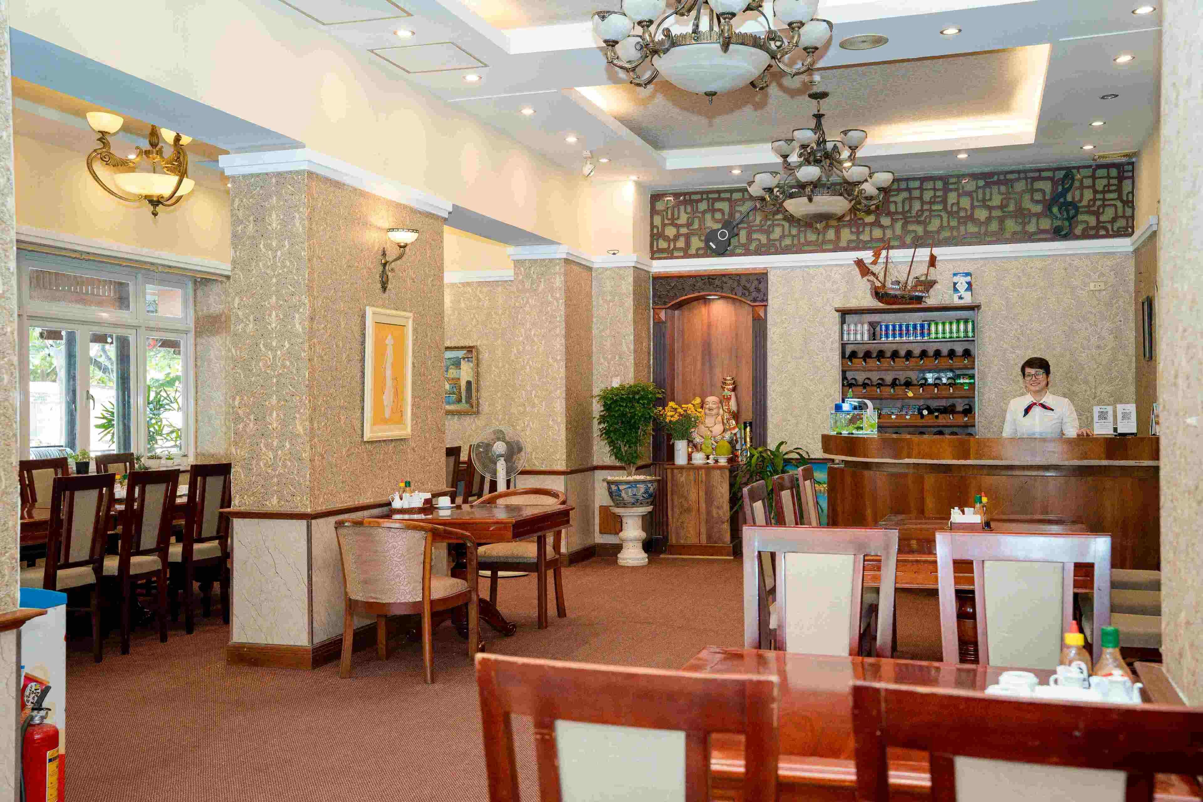 A hotel lobby with wooden furniture, a reception desk, and a bar area.