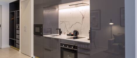 A modern kitchen with integrated appliances, a built-in oven, and a marble backsplash.