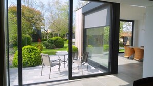 Una habitación moderna con un amplio ventanal corredero que da a un patio al aire libre.
