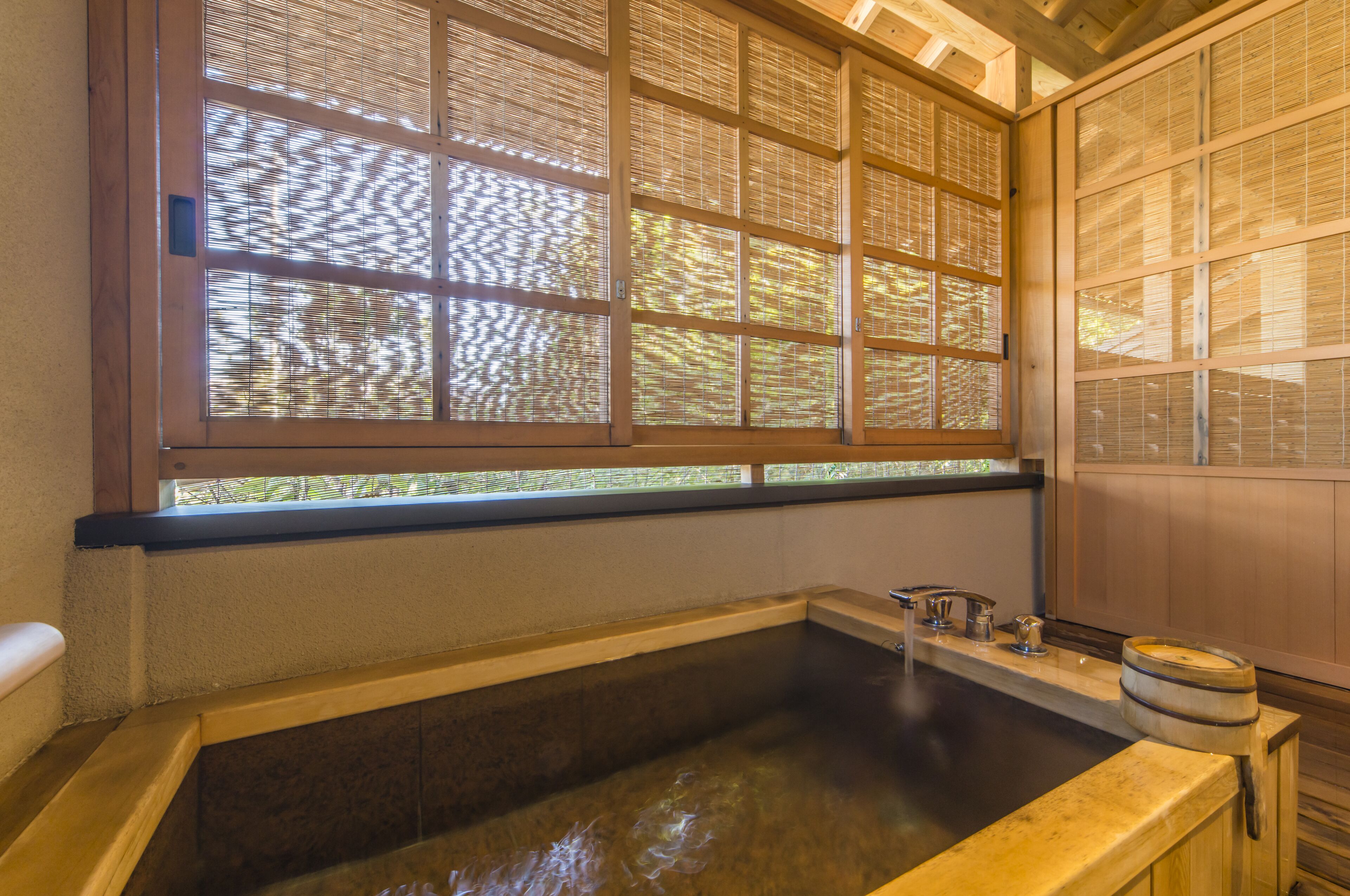 A traditional Japanese-style bath with sliding doors and a wooden interior.