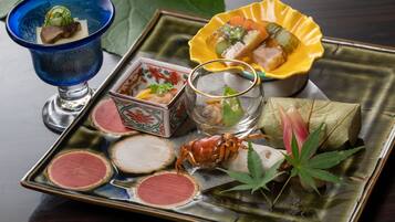 Un plateau contenant divers plats japonais, notamment des sushis, des sashimis et du crabe.