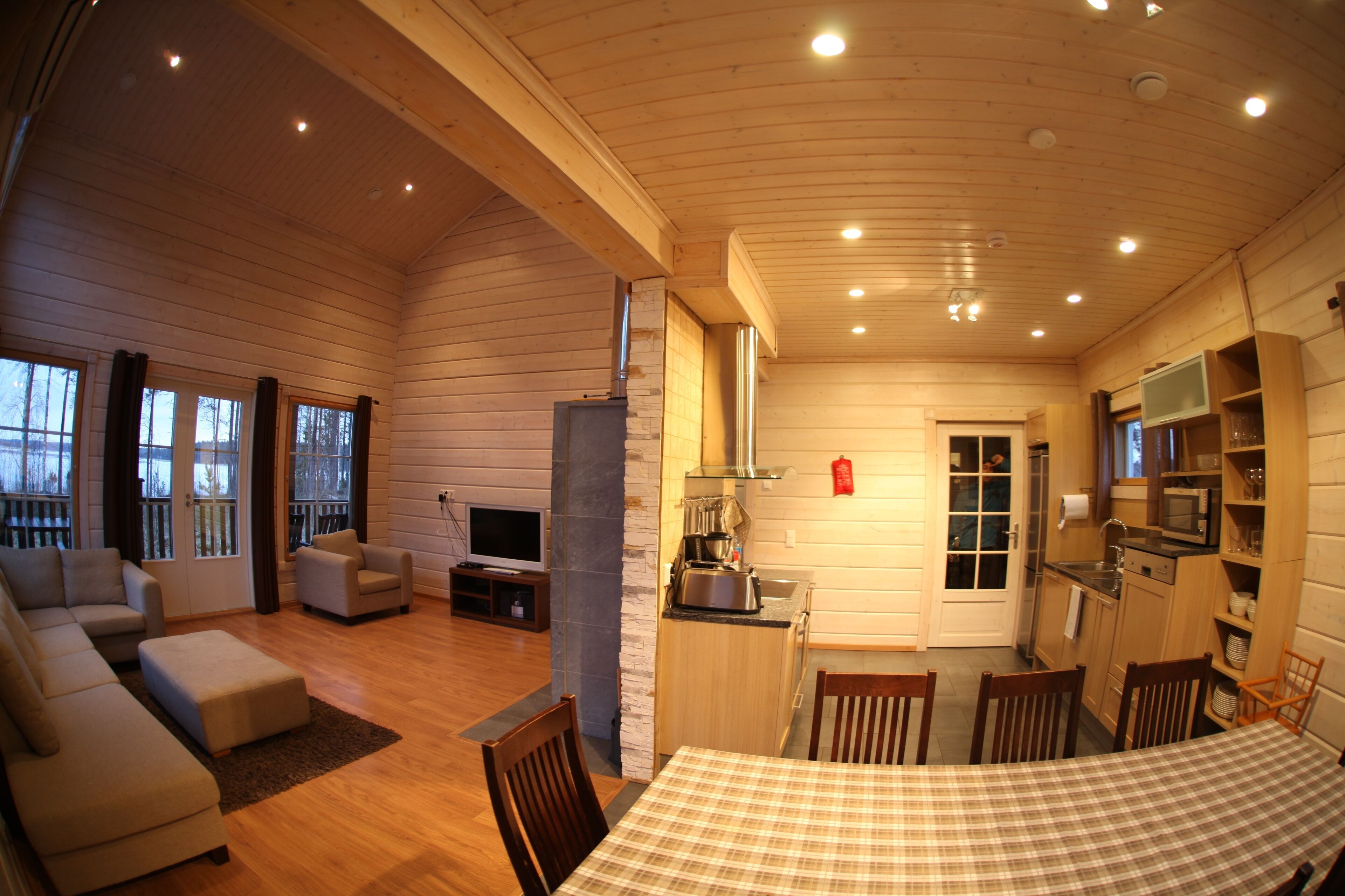 A cozy cabin interior with a living room, dining area, and kitchen.