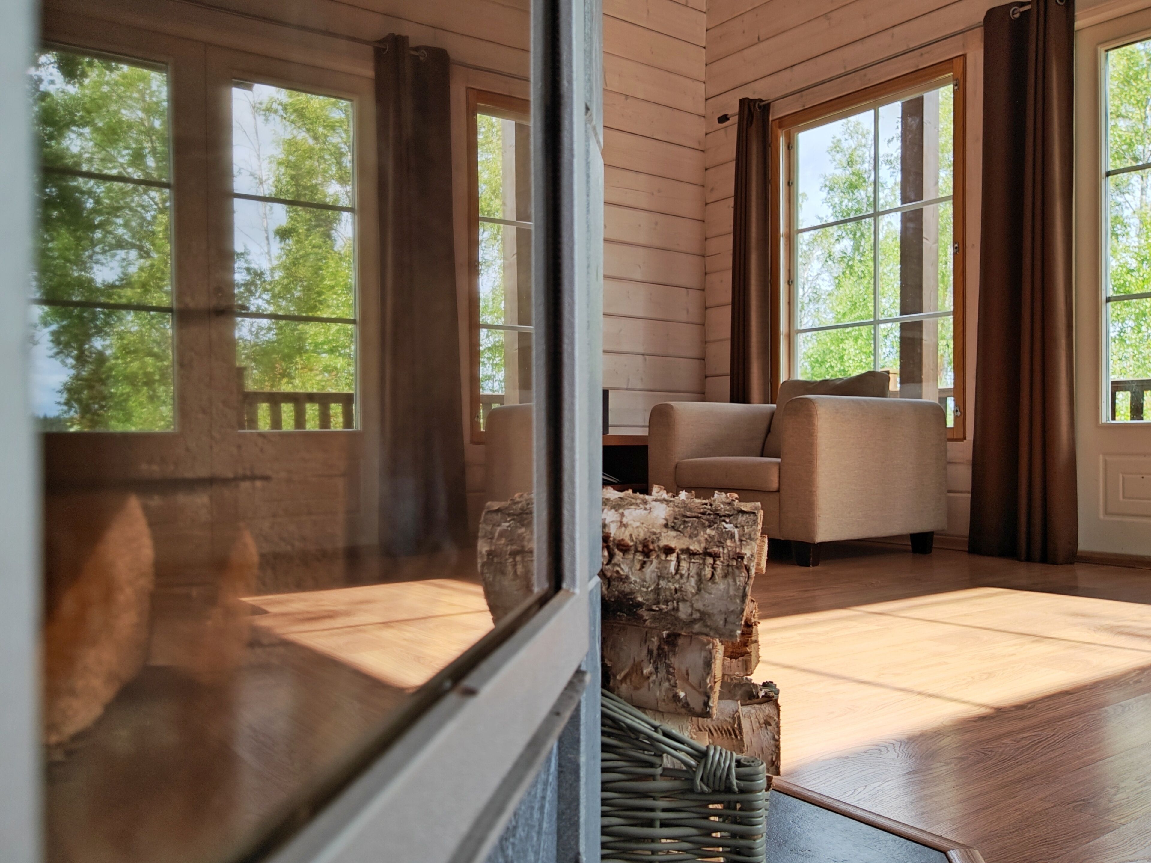 Une pièce avec de grandes fenêtres, un plancher en bois et un canapé.