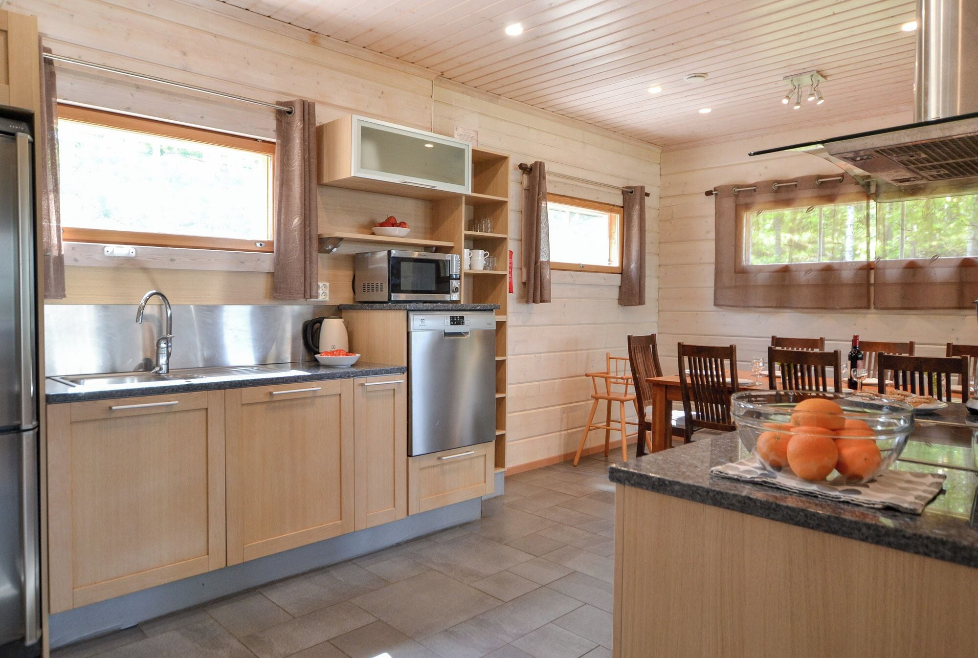 Une cuisine moderne avec des meubles en bois, des appareils électroménagers en acier inoxydable et une grande fenêtre.