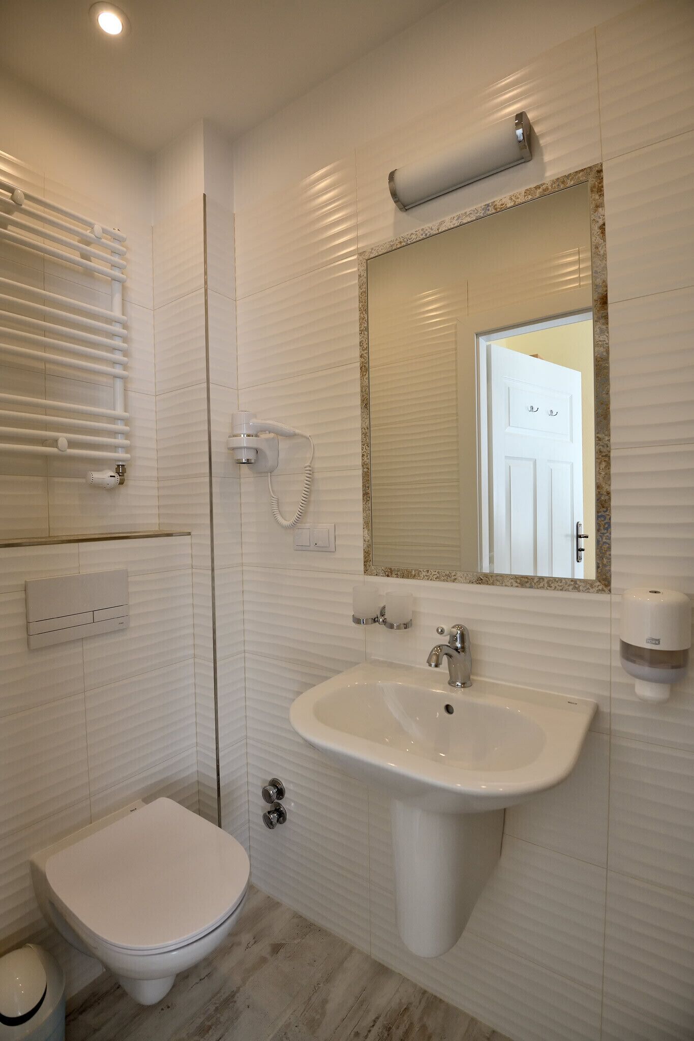 Ein modernes Badezimmer mit Toilette, Waschbecken und Dusche.