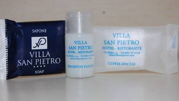 Un jabón, una botella de champú y una presentación de loción corporal del Hotel - Ristorante Villa San Pietro.
