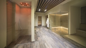 Ein modernes Badezimmer mit Duschkabine aus Glas, Holzboden und einer Glastrennwand.