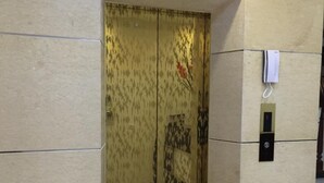 A modern elevator with a patterned door and a digital display.