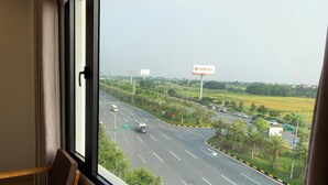 A hotel room with a large window overlooking a highway and a billboard.