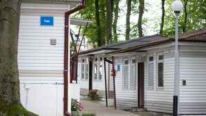 Une rangée de maisons mobiles blanches, avec une enseigne bleue portant l’inscription « Pasat » sur le côté gauche.