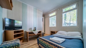 Une chambre avec un lit, une télévision, un bureau et une fenêtre.