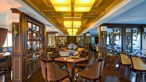 A formal dining room with a long table, multiple chairs, and a chandelier. - Paradise Elegance Cruise (Tuan Chau)