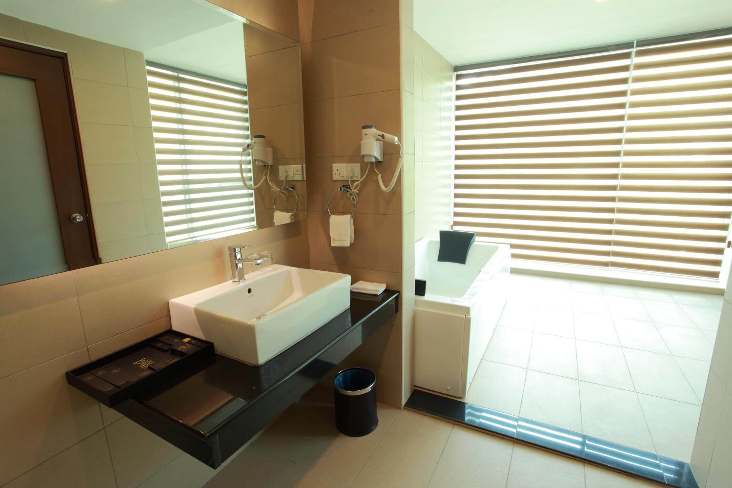 A modern bathroom with a sink, mirror, and a bathtub.