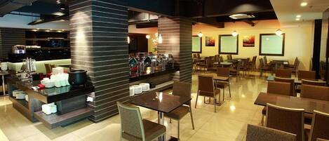A modern restaurant with a bar area, multiple seating options, and a clean, contemporary design.