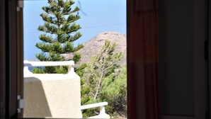 A window view of a mountain and pine trees. - Studios Apts Lagos (Sitia)