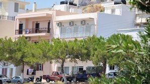 A residential area with multi-story buildings, balconies, and parked cars. - Nora Hotel (Sitia)
