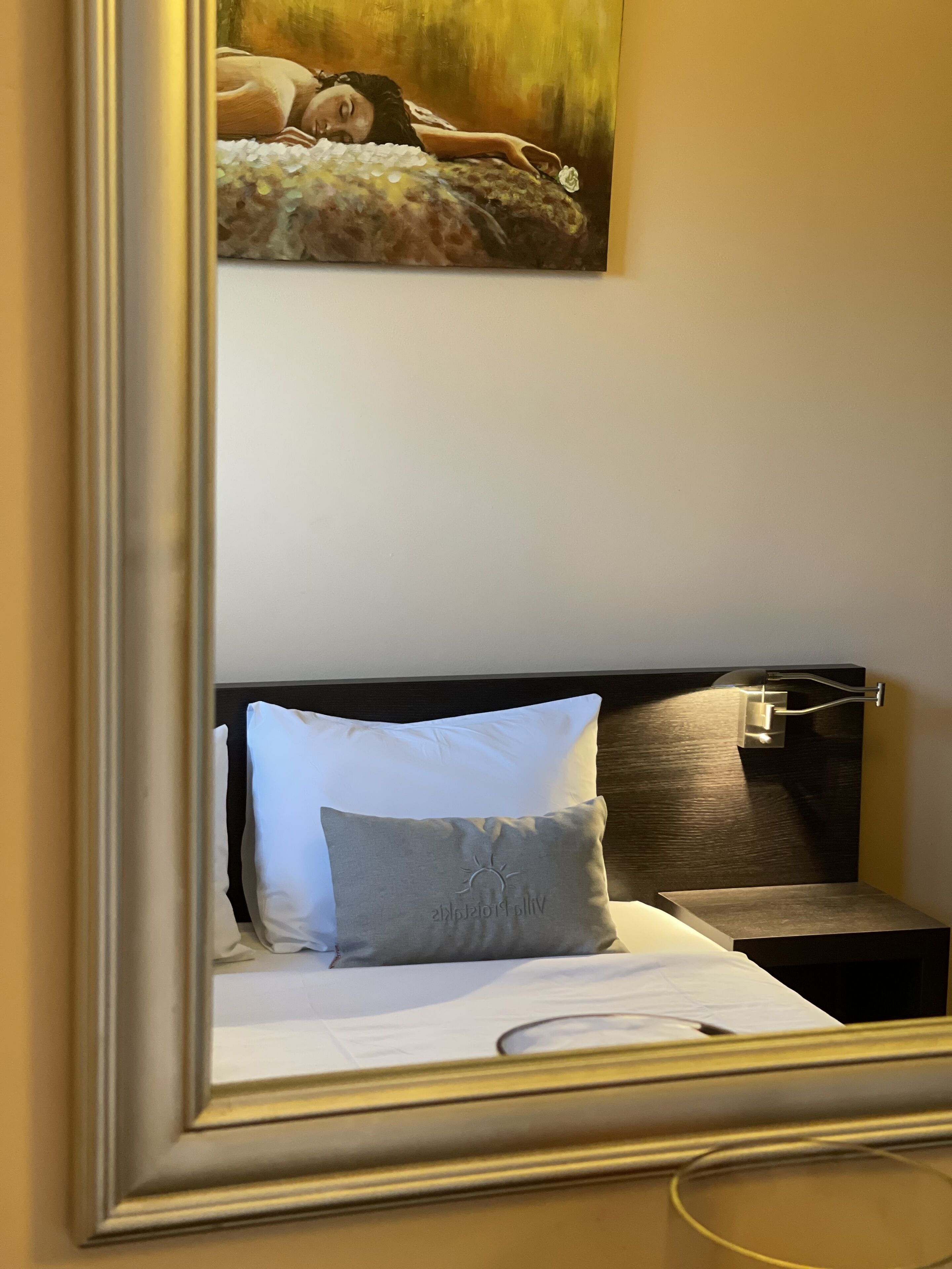 Une chambre d’hôtel avec un lit, une table de chevet, une lampe et un tableau au mur.