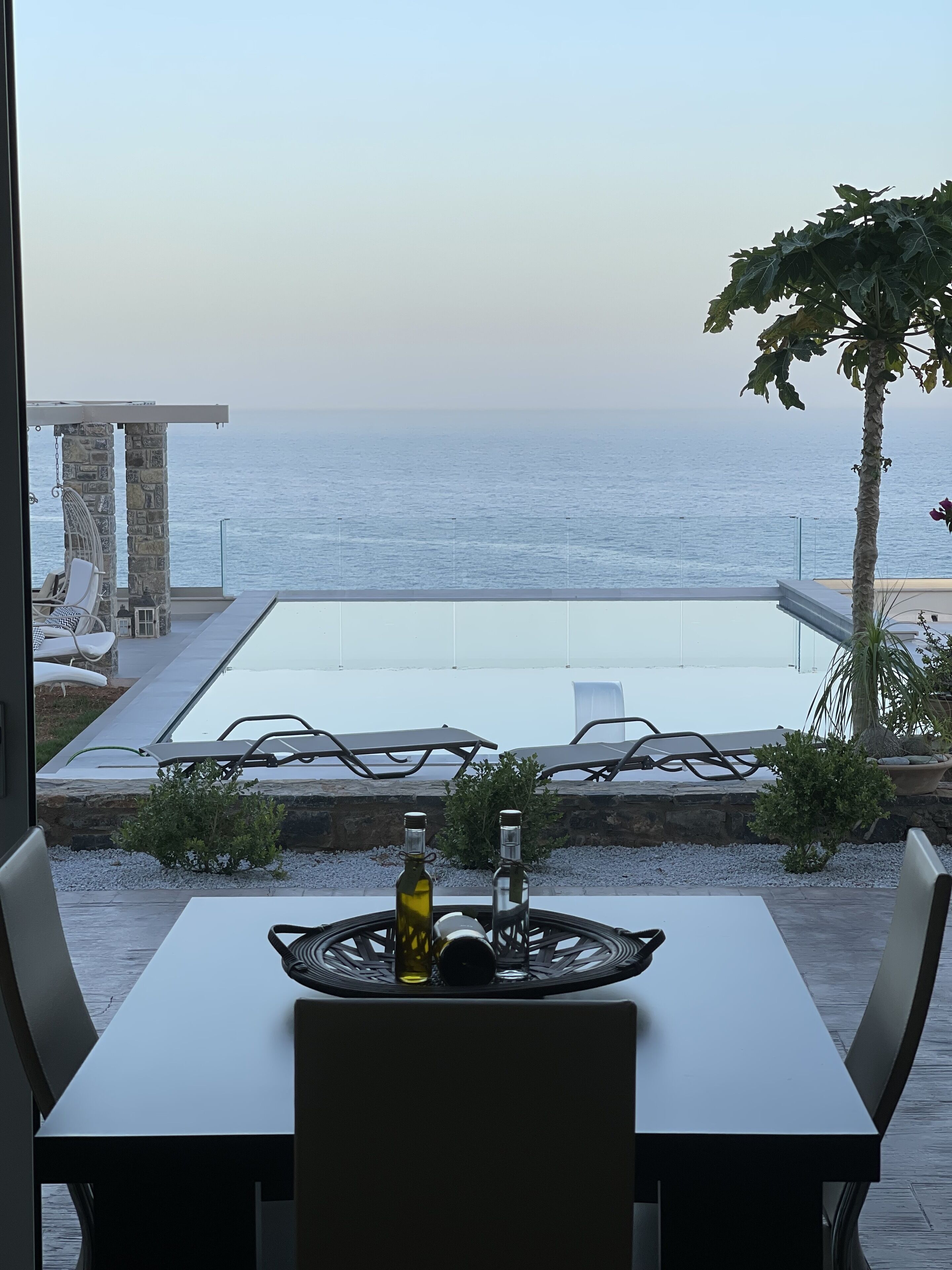 Vista desde un balcón con vista a una piscina y al mar.