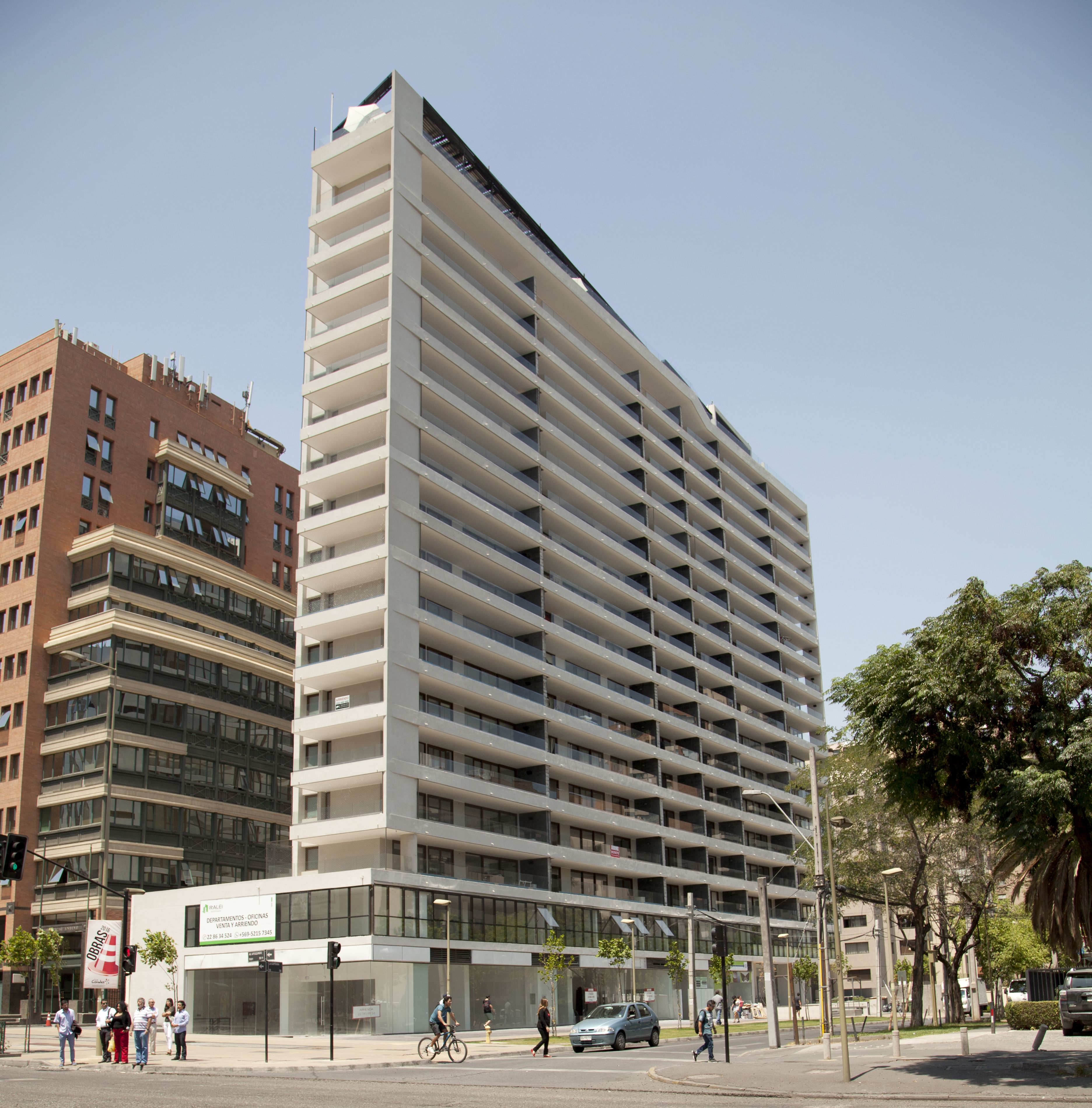 A modern high-rise building with multiple floors and balconies, featuring a glass facade and a flat roof.