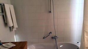 A bathroom with a bathtub, a shower, a sink, and a towel rack. - Hotel The New Fox (Affligem)