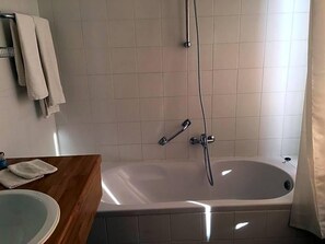 A bathroom with a bathtub, a shower, a sink, and a towel rack. - Hotel The New Fox (Affligem)