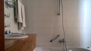 A bathroom with a wooden vanity, a sink, a bathtub, and a shower. - Hotel The New Fox (Affligem)