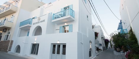 Un edificio blanco con un letrero que dice "GEORGIA MARE" y balcones con barandillas azules.