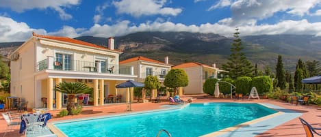 Alberca al aire libre, sombrillas en la alberca y camastros