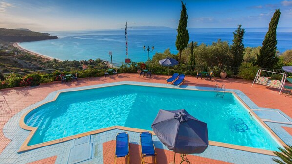 Piscine extérieure, parasols de plage, chaises longues